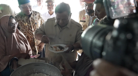 Prabowo mencicipi masakan ikan tongkol di dapur pengungsian Aceh saat meninjau kelayakan gizi makanan bagi warga terdampak bencana. (Facebook.com @Setkab RI)