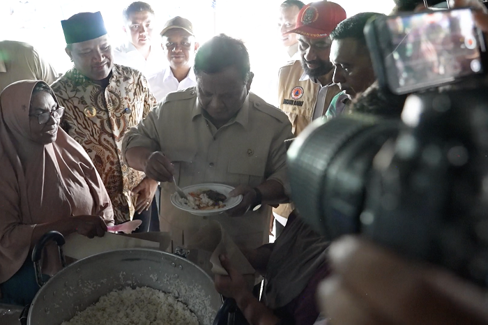 Prabowo mencicipi masakan ikan tongkol di dapur pengungsian Aceh saat meninjau kelayakan gizi makanan bagi warga terdampak bencana. (Facebook.com @Setkab RI)
