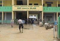 Personel Brimob Polda Aceh membersihkan lumpur di ruang kelas SMP Swasta Islam Kuala Simpang, Aceh Tamiang, pascabanjir bandang. (Dok. Tim Media Prabowo)