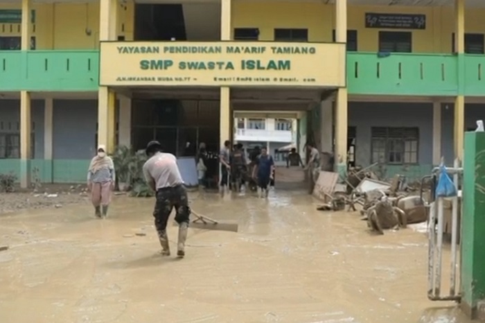 Personel Brimob Polda Aceh membersihkan lumpur di ruang kelas SMP Swasta Islam Kuala Simpang, Aceh Tamiang, pascabanjir bandang. (Dok. Tim Media Prabowo)